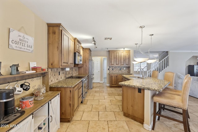 12748 N 57th Dr, Glendale, AZ 85304 - kitchen with stainless steel appliances, a sink, decorative backsplash, and brown cabinets