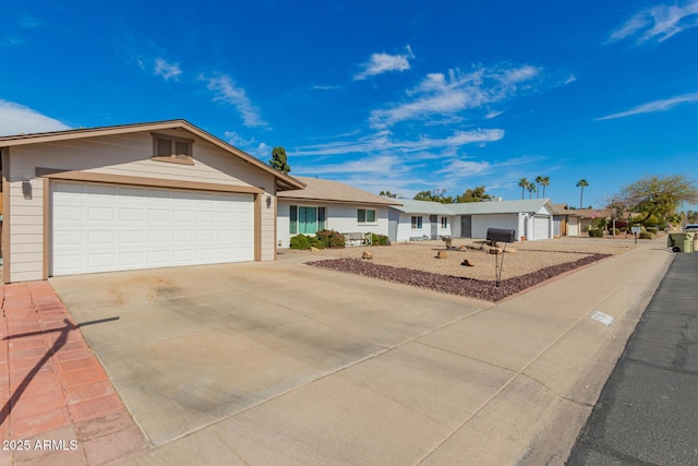 ranch-style home with concrete driveway, an attached garage, and a residential view