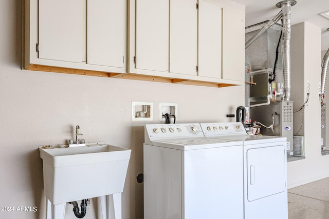 laundry room with cabinets, washing machine and clothes dryer, and sink