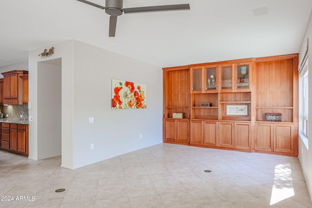 unfurnished living room featuring ceiling fan and plenty of natural light