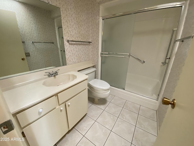 bathroom with a shower with door, toilet, vanity, and tile patterned flooring