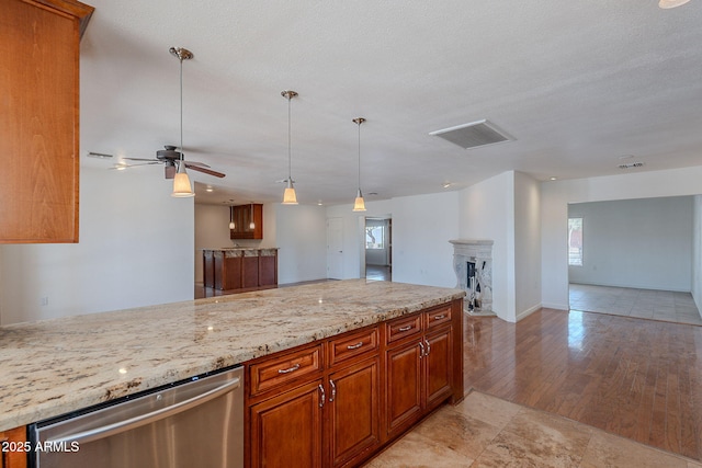 5539 E Dahlia Dr, Scottsdale, AZ 85254 - kitchen with stainless steel dishwasher, open floor plan, light stone countertops, brown cabinets, and ceiling fan