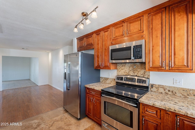 5539 E Dahlia Dr, Scottsdale, AZ 85254 - kitchen featuring appliances with stainless steel finishes, brown cabinets, and light stone counters