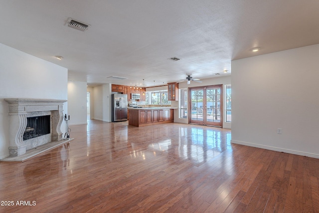 5539 E Dahlia Dr, Scottsdale, AZ 85254 - unfurnished living room featuring baseboards, light wood-style floors, a fireplace, and a ceiling fan
