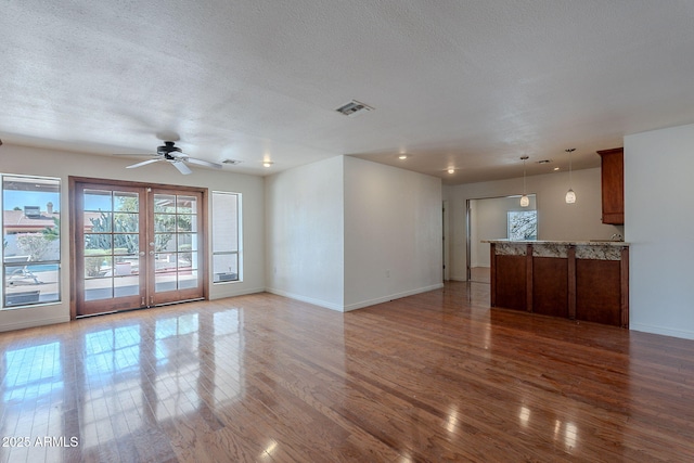 5539 E Dahlia Dr, Scottsdale, AZ 85254 - unfurnished living room featuring baseboards, wood finished floors, ceiling fan, french doors, and a textured ceiling