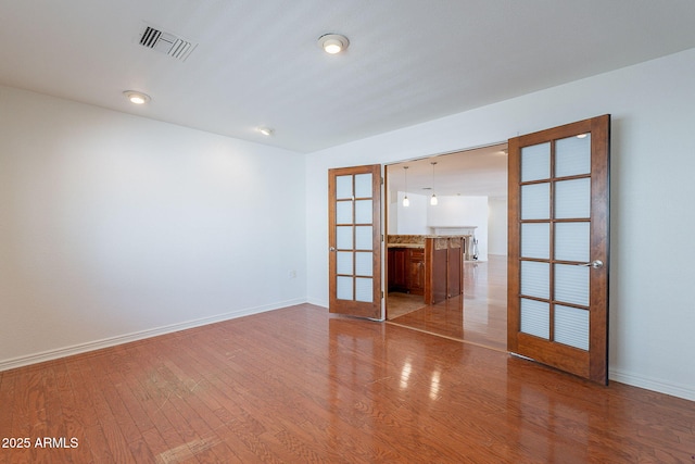 5539 E Dahlia Dr, Scottsdale, AZ 85254 - spare room with french doors, wood finished floors, and baseboards