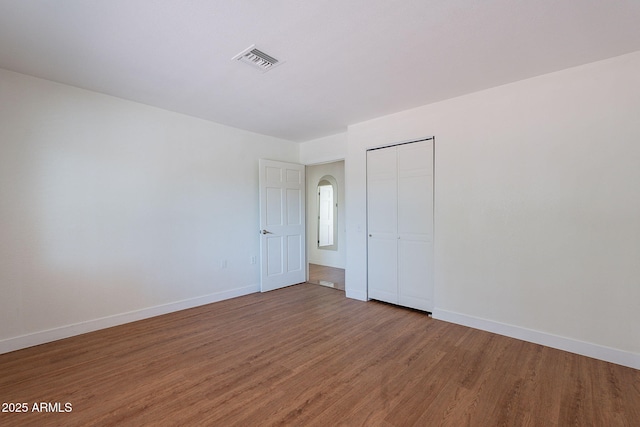 5539 E Dahlia Dr, Scottsdale, AZ 85254 - empty room with light wood finished floors, baseboards, and arched walkways