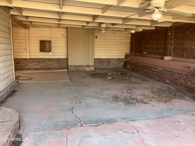 miscellaneous room with ceiling fan, brick wall, and wooden walls