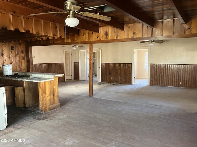 basement with ceiling fan, wooden walls, and wooden ceiling