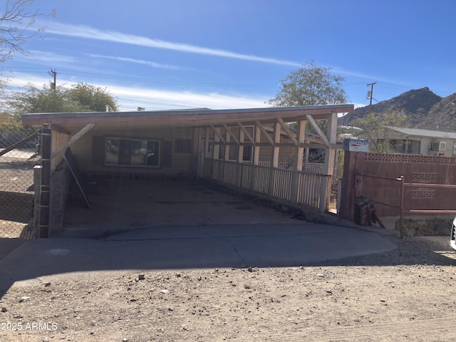 back of property with a mountain view and a carport