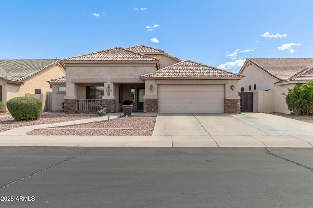 10815 W Sheridan St, Avondale, AZ 85392 - view of front facade with a tile roof, stone siding, concrete driveway, stucco siding, and an attached garage