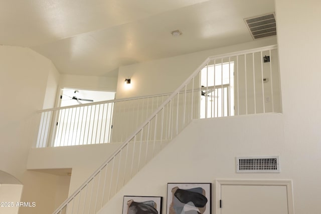 stairs featuring high vaulted ceiling, visible vents, and a ceiling fan