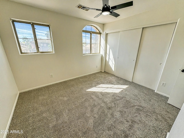 unfurnished bedroom featuring carpet floors, a ceiling fan, baseboards, and a closet