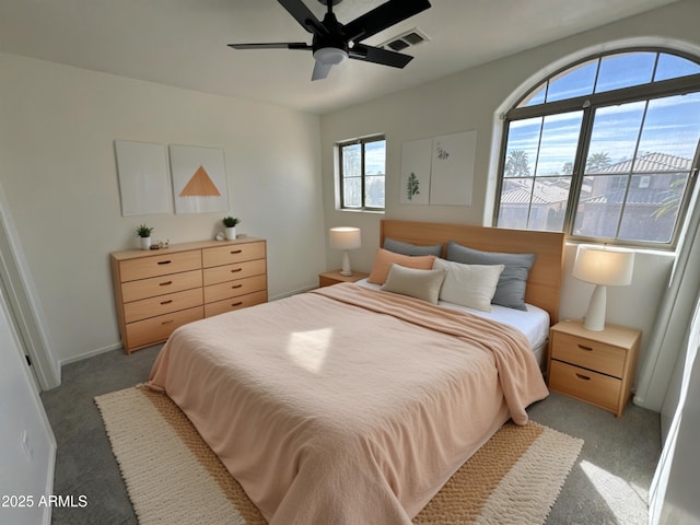 bedroom featuring a ceiling fan, visible vents, and light carpet