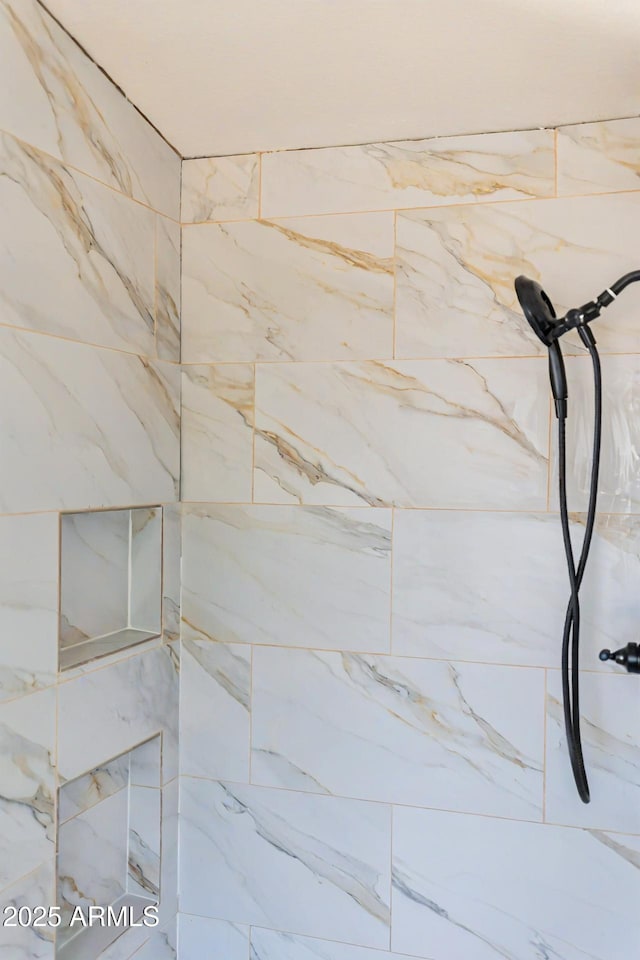 interior details featuring tiled shower