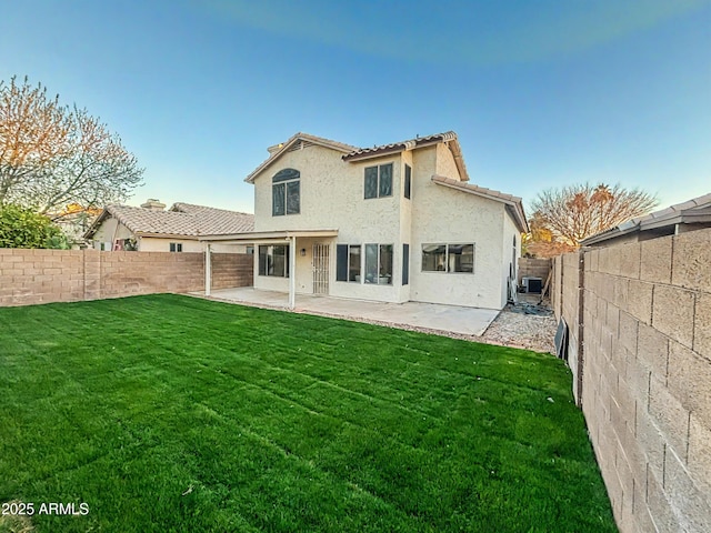 back of house with a lawn, a patio area, a fenced backyard, and stucco siding