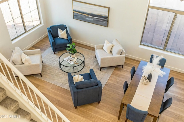 living area with stairs, baseboards, and wood finished floors