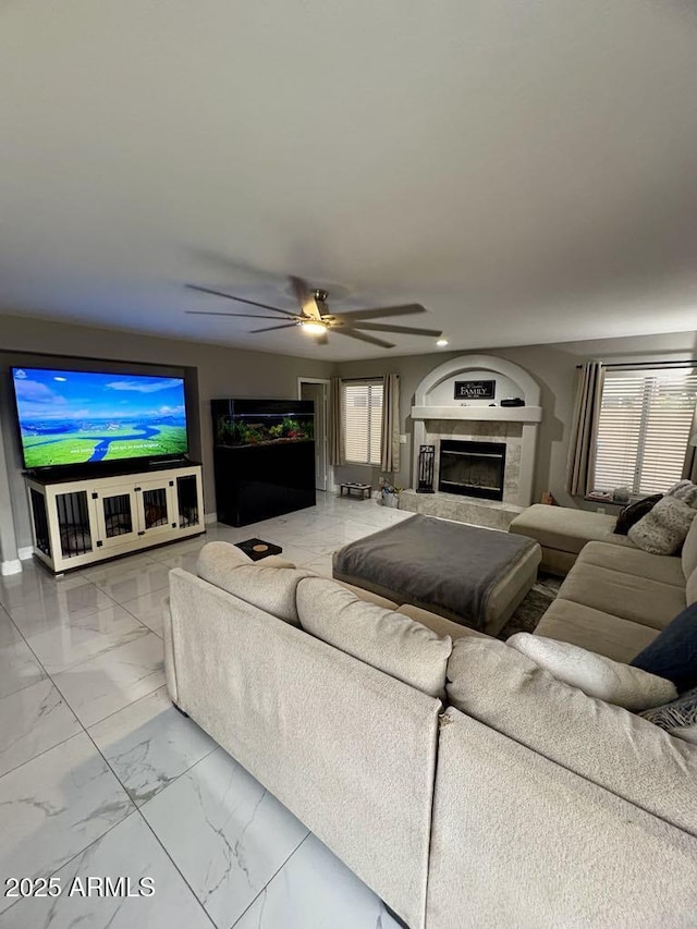 135 S Abalone Dr, Gilbert, AZ 85233 - living area with marble look tiles, a tiled fireplace, and ceiling fan