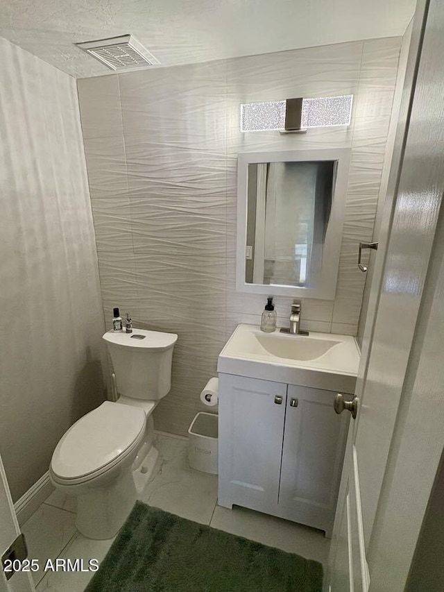 135 S Abalone Dr, Gilbert, AZ 85233 - half bathroom with vanity, toilet, baseboards, and tile walls