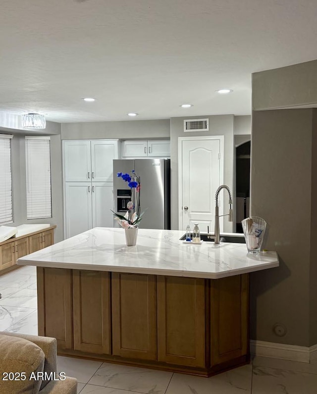 135 S Abalone Dr, Gilbert, AZ 85233 - kitchen featuring stainless steel fridge with ice dispenser, light marble finish flooring, light stone countertops, a sink, and recessed lighting