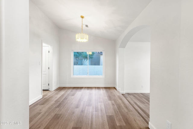 3037 E Bighorn Ave, Phoenix, AZ 85048 - spare room featuring arched walkways, baseboards, vaulted ceiling, and light wood finished floors
