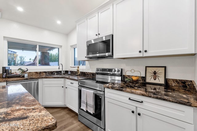 3037 E Bighorn Ave, Phoenix, AZ 85048 - kitchen with dark stone counters, appliances with stainless steel finishes, a sink, and white cabinets