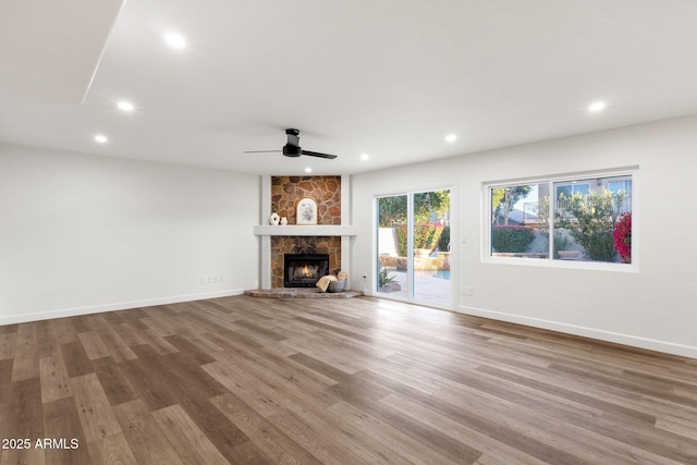 3037 E Bighorn Ave, Phoenix, AZ 85048 - unfurnished living room featuring baseboards, ceiling fan, wood finished floors, a stone fireplace, and recessed lighting