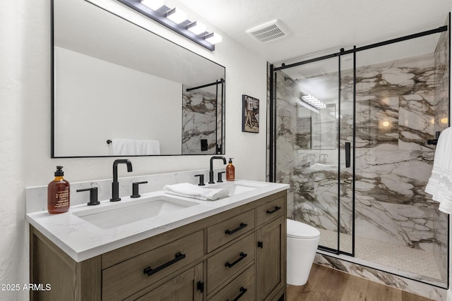 3037 E Bighorn Ave, Phoenix, AZ 85048 - bathroom with a marble finish shower, visible vents, a sink, and wood finished floors