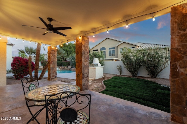 3037 E Bighorn Ave, Phoenix, AZ 85048 - patio terrace at dusk with a ceiling fan, a fenced in pool, outdoor dining area, and an outdoor kitchen