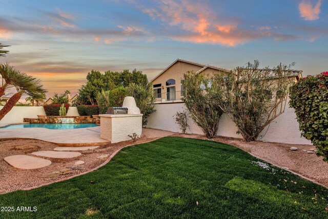 3037 E Bighorn Ave, Phoenix, AZ 85048 - yard at dusk featuring an outdoor pool and an outdoor kitchen
