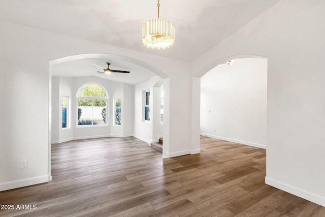 3037 E Bighorn Ave, Phoenix, AZ 85048 - unfurnished room featuring baseboards, arched walkways, a ceiling fan, wood finished floors, and vaulted ceiling