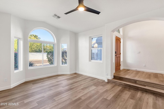 3037 E Bighorn Ave, Phoenix, AZ 85048 - empty room with arched walkways, baseboards, visible vents, and light wood finished floors