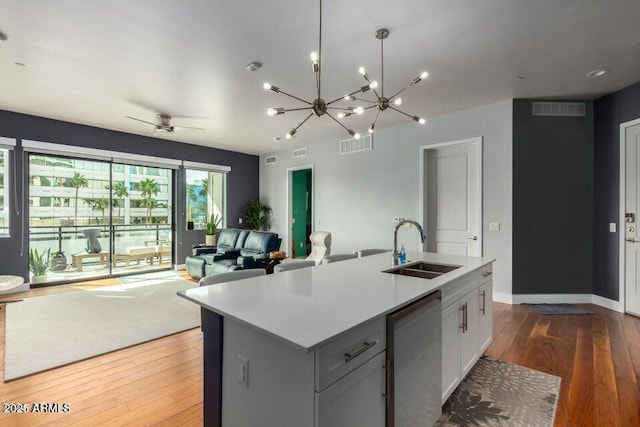 kitchen with white cabinetry, sink, an island with sink, and dishwasher