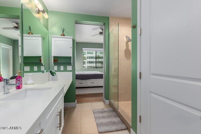 bathroom with ceiling fan, tile patterned floors, vanity, and a tile shower