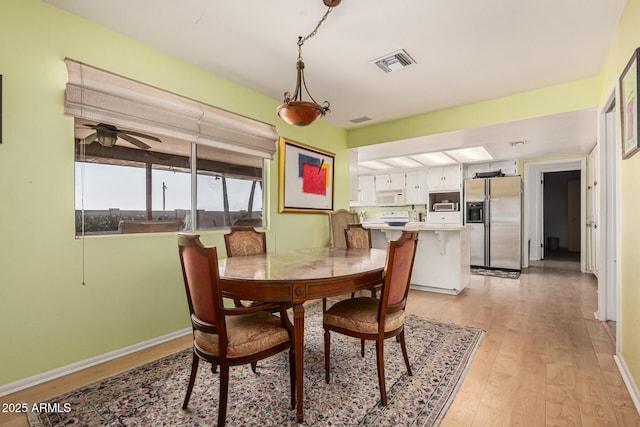 dining room with ceiling fan and light hardwood / wood-style flooring