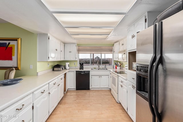 kitchen with white appliances, sink, light hardwood / wood-style flooring, and white cabinets