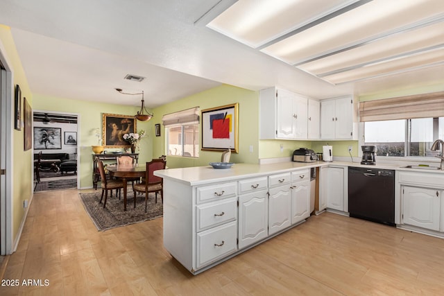 kitchen with pendant lighting, white cabinetry, black dishwasher, light hardwood / wood-style floors, and kitchen peninsula