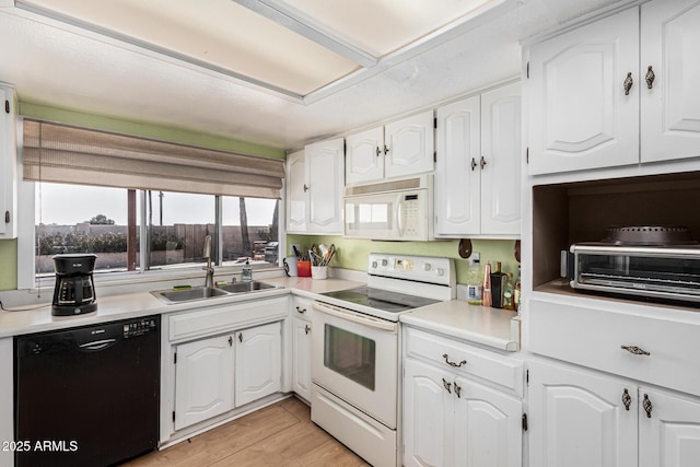 kitchen featuring white cabinetry, white appliances, sink, and light hardwood / wood-style flooring