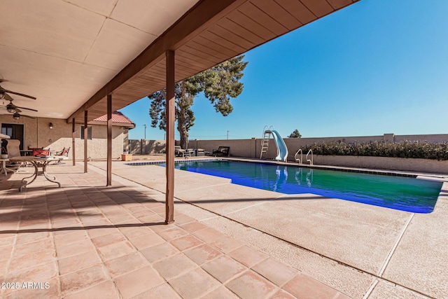 view of pool featuring ceiling fan, a water slide, and a patio