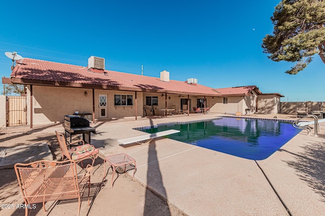 view of pool with a diving board and a patio