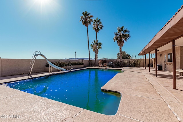 view of swimming pool featuring a water slide and a patio area