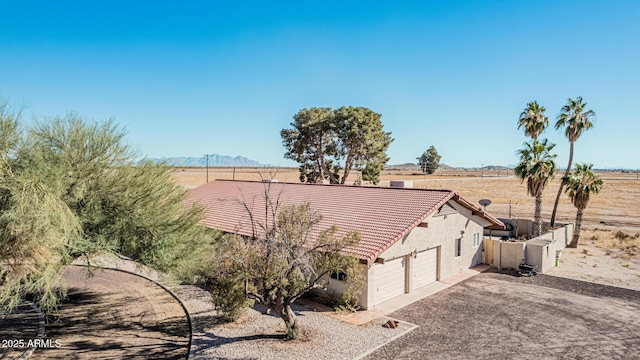 view of property exterior with a mountain view and a rural view