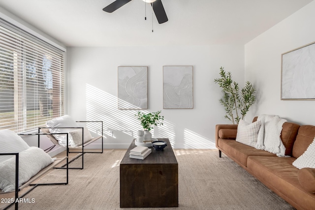 living room with a ceiling fan and baseboards