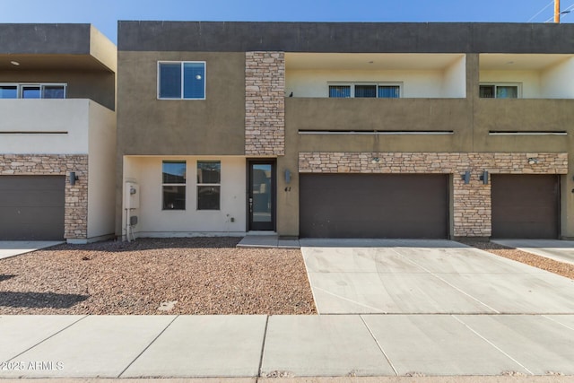 2000 N 36th St Unit 41, Phoenix, AZ 85008 - view of front of house featuring stucco siding, a garage, driveway, and stone siding