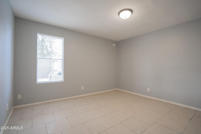 unfurnished room with baseboards