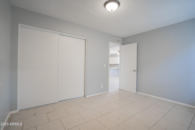 unfurnished bedroom featuring baseboards, visible vents, and a closet