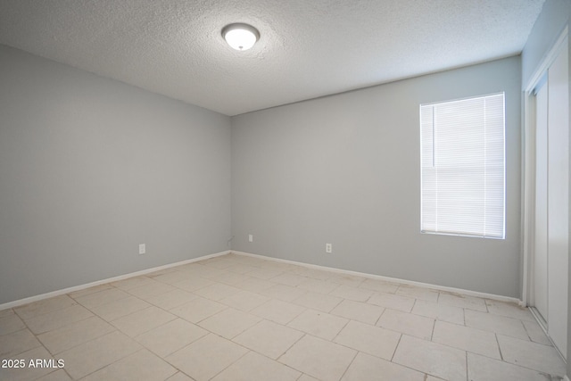 empty room featuring baseboards and a textured ceiling