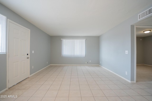 empty room with baseboards, visible vents, and a wealth of natural light