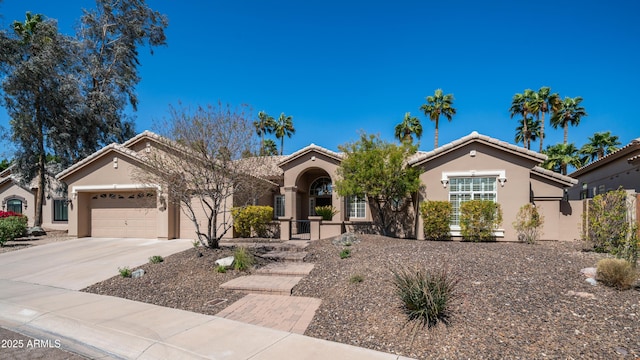 view of front of property with stucco siding, driveway, an attached garage, and a tile roof