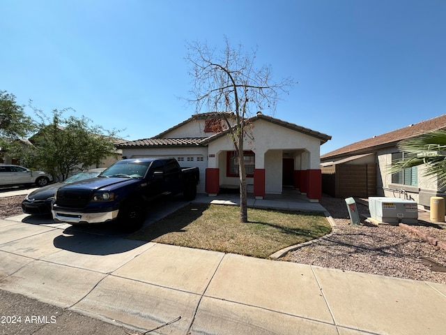 view of front of property with central air condition unit and a garage